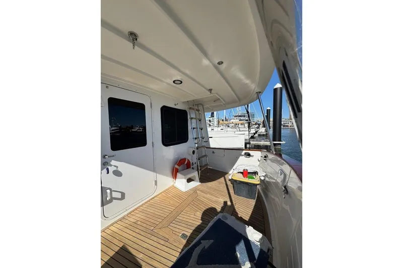 Slide: The Image of 2008 Kadey-Krogen 44 Walk Around yacht deck with wooden flooring and marina view. - 78