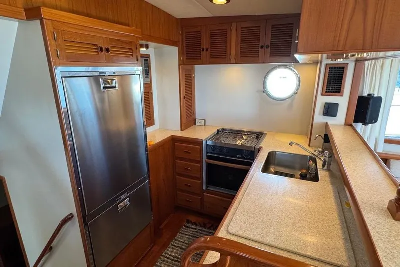 Slide: The Image of 2008 Kadey-Krogen 44 Walk Around yacht kitchen with stainless steel appliances and wooden cabinetry. - 34