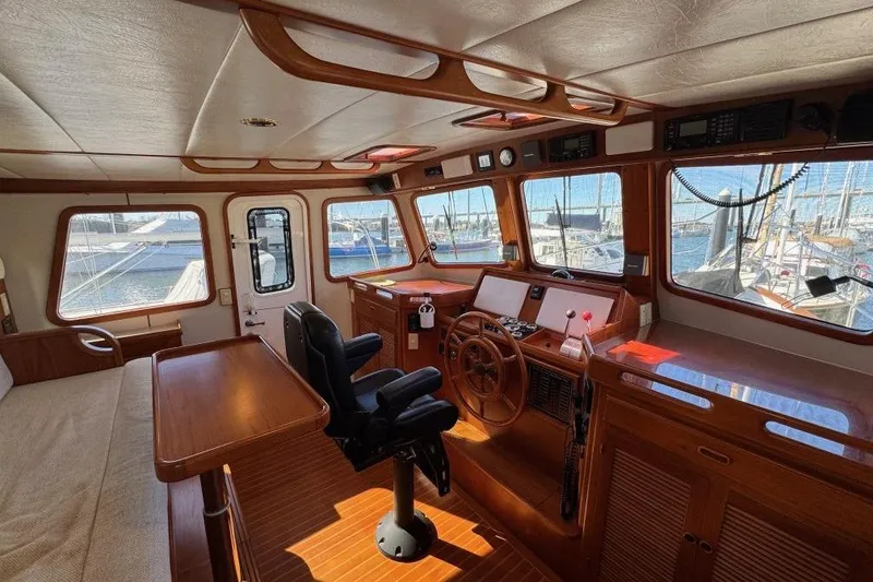 Slide: The Image of 2008 Kadey-Krogen 44 Walk Around yacht interior with helm, wooden finishes, and marina view. - 64