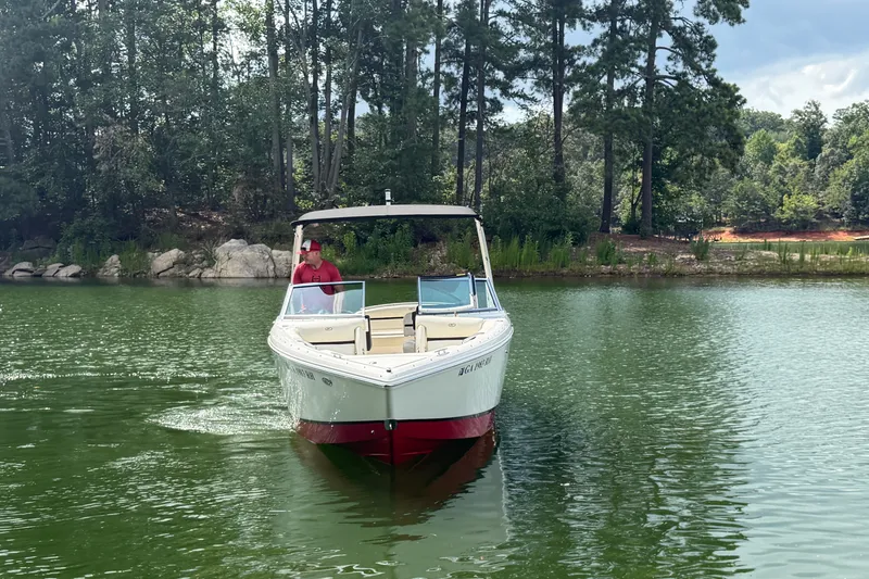 Slide: The Image of 2019 Cobalt R5 boat cruising on a serene lake with lush forest backdrop. - 9