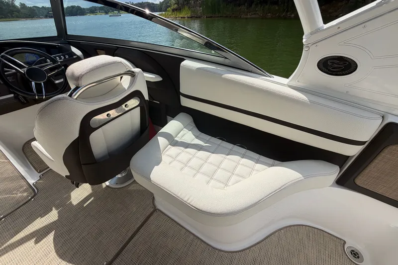 Slide: The Image of 2019 Cobalt R5 boat interior with white seating and steering wheel, overlooking a serene lake. - 28