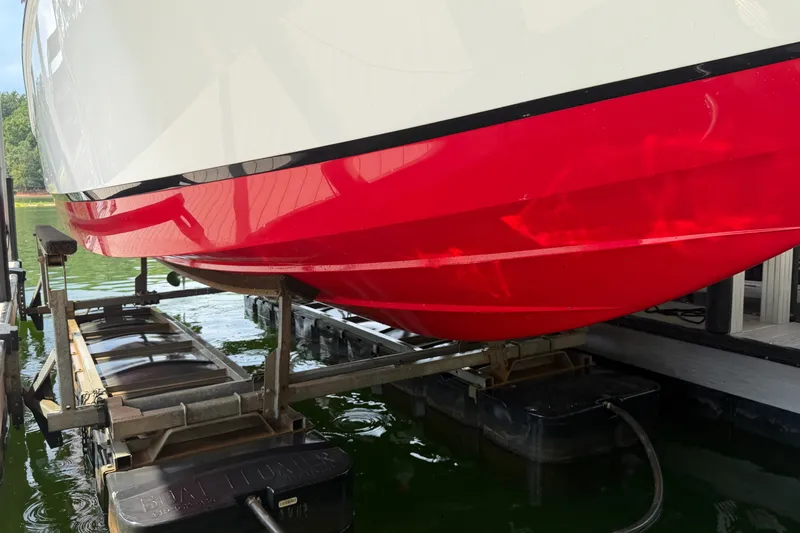 Slide: The Image of 2019 Cobalt R5 boat hull in vibrant red on a lift by the water. - 35