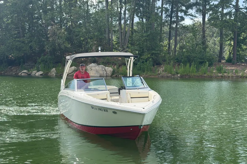 Slide: The Image of 2019 Cobalt R5 boat cruising on a serene lake surrounded by lush greenery. - 8