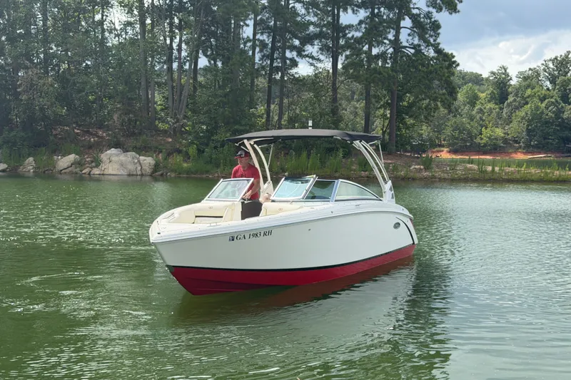 Slide: The Image of 2019 Cobalt R5 boat cruising on a serene lake with lush green surroundings. - 13