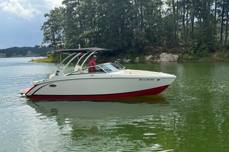 Slide: The Image of 2019 Cobalt R5 boat cruising on a serene lake with lush forest backdrop. - 2