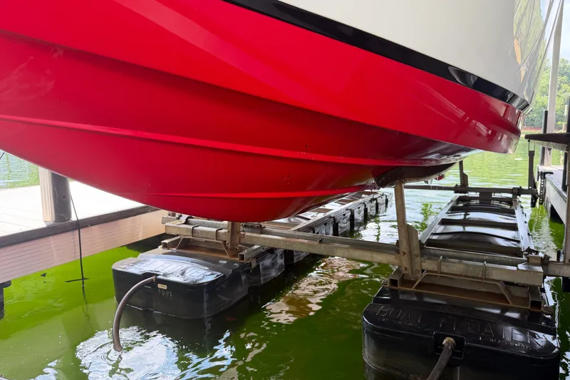 Slide: The Image of Red 2019 Cobalt R5 boat hull on a lift above green water. - 34