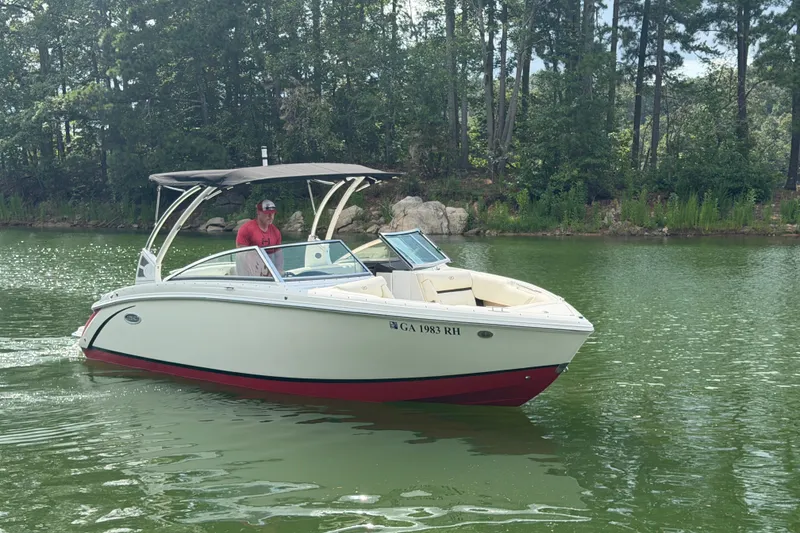 Slide: The Image of 2019 Cobalt R5 boat cruising on a serene lake with lush green surroundings. - 6