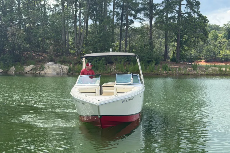 Slide: The Image of 2019 Cobalt R5 boat cruising on a serene lake with lush forest backdrop. - 10