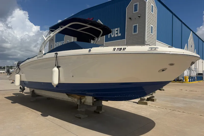 Slide: The Image of 2016 Sea Ray 290 Sundeck Outboard boat on dry dock, blue and white exterior. - 3
