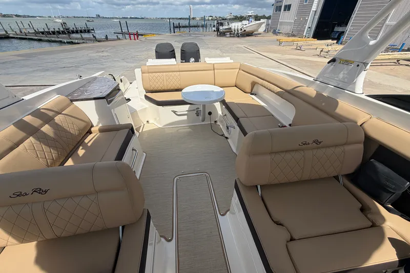 Slide: The Image of 2016 Sea Ray 290 Sundeck Outboard with spacious seating and elegant design docked by the water. - 5