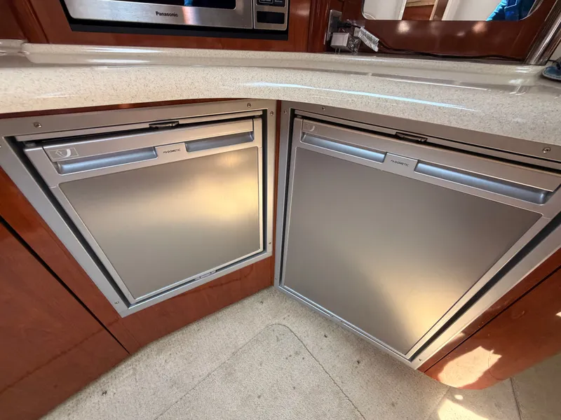 Slide: The Image of The 2004 Sea Ray 420 Sundancer's galley features two stainless steel refrigerators and a countertop. - 36