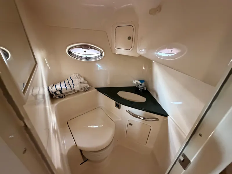 Slide: The Image of The image shows a sleek boat bathroom with a porthole and neatly folded towels. - 35