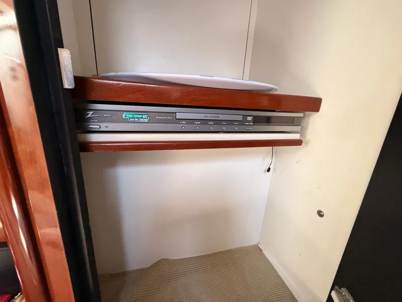 Slide: The Image of A built-in DVD player in a wood-paneled cabinet on a 2004 Sea Ray 420 Sundancer. - 44