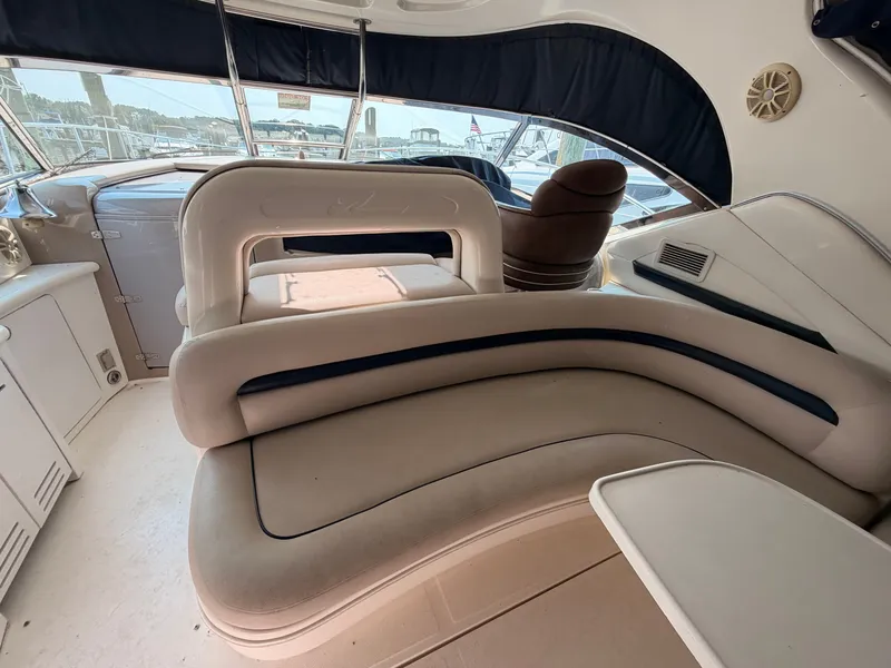 Slide: The Image of The image shows the cockpit of a 2004 Sea Ray 420 Sundancer with curved seating and a table. - 13