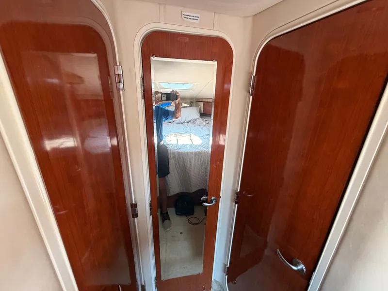 Slide: The Image of The interior of a 2004 Sea Ray 420 Sundancer features a cabin with wooden doors and a mirror. - 42