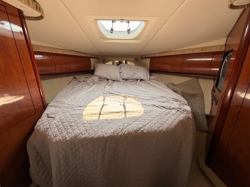 Slide: The Image of The 2004 Sea Ray 420 Sundancer cabin features a cozy bed with wooden cabinetry. - 38