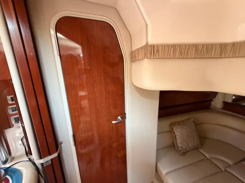 Slide: The Image of Interior of a 2004 Sea Ray 420 Sundancer with a wooden door and beige sofa. - 34
