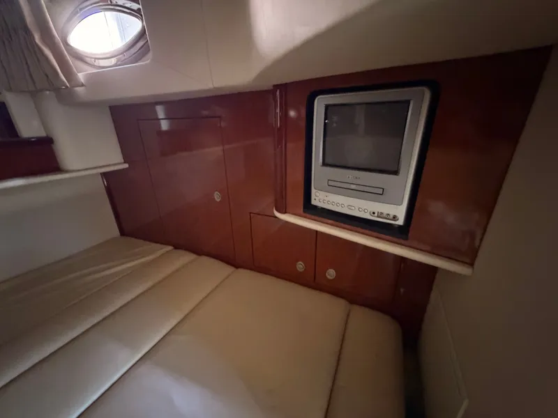 Slide: The Image of Interior of a 2004 Sea Ray 420 Sundancer featuring a built-in TV and a bed. - 32