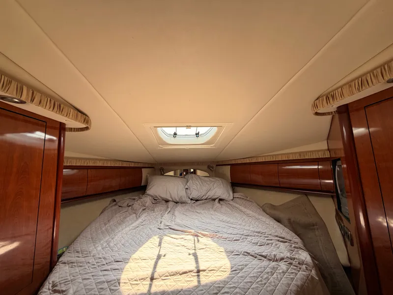 Slide: The Image of The cabin of the 2004 Sea Ray 420 Sundancer features a cozy bed with wooden cabinetry. - 39