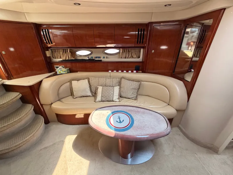 Slide: The Image of Interior of a 2004 Sea Ray 420 Sundancer with beige sofa and wooden table. - 30