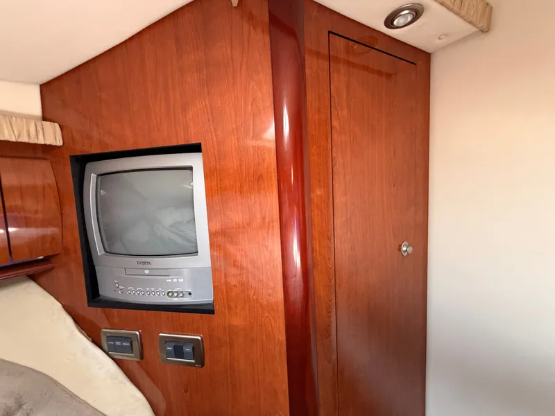 Slide: The Image of A sleek wooden cabinet with a built-in TV and switches in a boat cabin. - 40