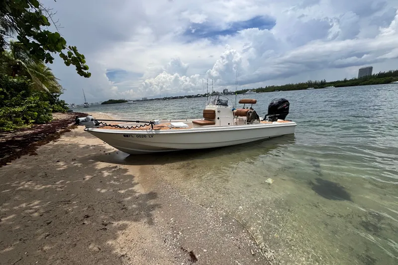Slide: The Image of 2002 Scout 240 Bay Scout boat on a sandy beach with cloudy sky backdrop. - 15