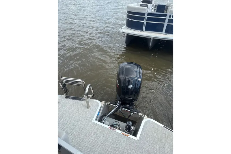 Slide: The Image of 2024 Harris Cruiser 230 pontoon boat with outboard motor on a calm lake. - 8