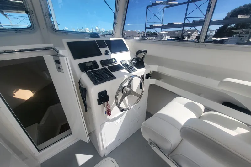 Slide: The Image of Steiger Craft 28 Miami 2020 boat interior with helm, steering wheel, and navigation equipment. - 15
