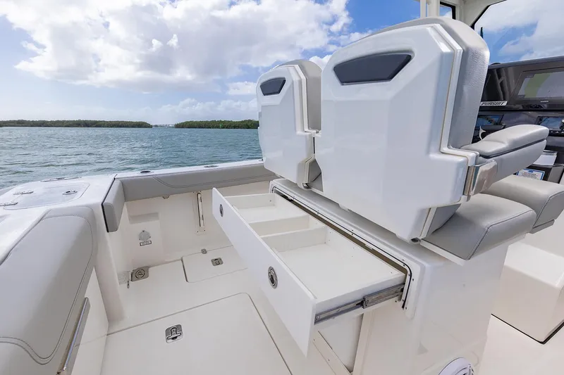 Slide: The Image of Manufacturer Provided Image: 2025 Pursuit S 248 Sport boat interior with open storage drawer, ocean view. - 9