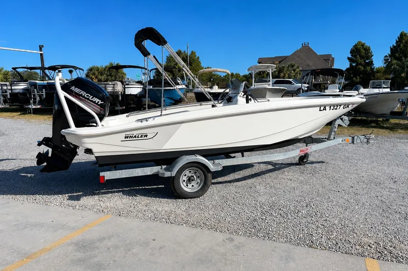 Slide: The Image of 2019 Boston Whaler 160 Super Sport boat on trailer with Mercury engine, parked outdoors. - 6
