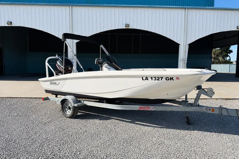 The Image of 2019 Boston Whaler 160 Super Sport boat on trailer, parked outside a building. - 0