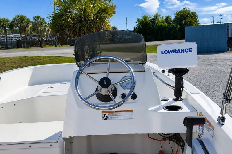 Slide: The Image of 2019 Boston Whaler 160 Super Sport boat dashboard with steering wheel and Lowrance navigation system. - 13