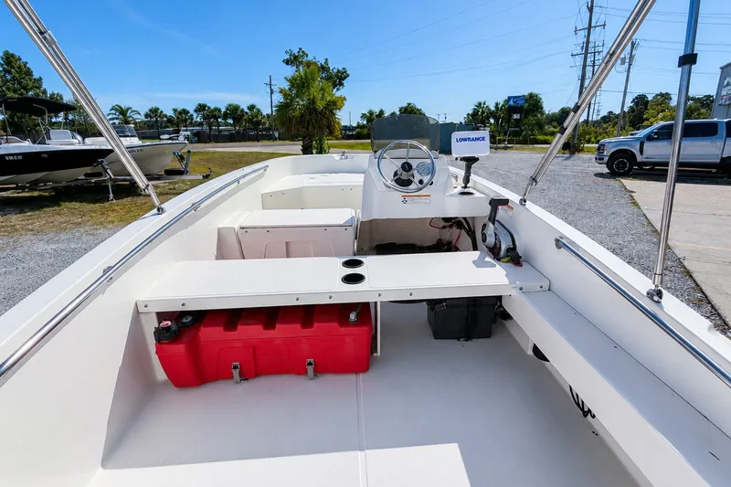 Slide: The Image of 2019 Boston Whaler 160 Super Sport boat interior with steering wheel and red storage box. - 12