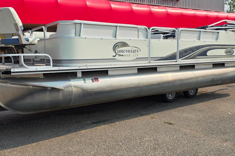 Slide: The Image of 2000 Lowe Suncruiser Trinidad 220 pontoon boat parked on pavement. - 2