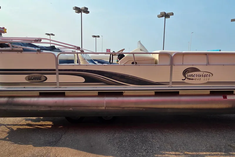 Slide: The Image of 2000 Lowe Suncruiser Trinidad 220 pontoon boat parked outdoors. - 4