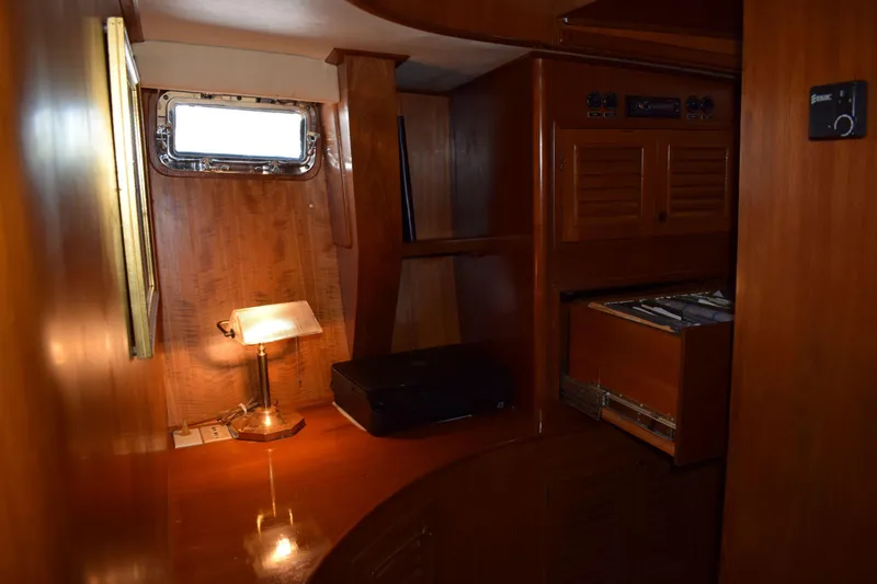 Slide: The Image of Interior of 1980 Cheoy Lee 52 Motorsailer with wooden cabinetry and desk lamp. - 83
