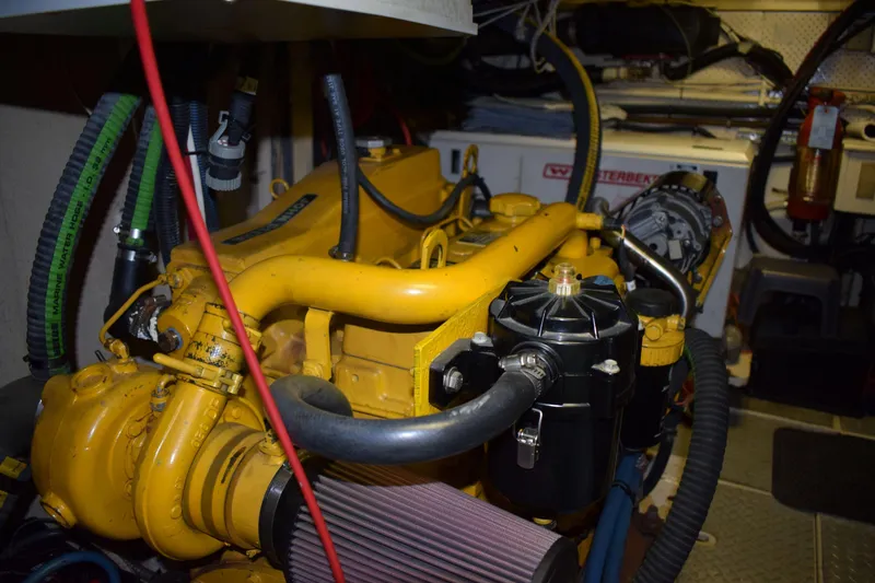Slide: The Image of Engine room of 1980 Cheoy Lee 52 Motorsailer with visible yellow machinery and hoses. - 95