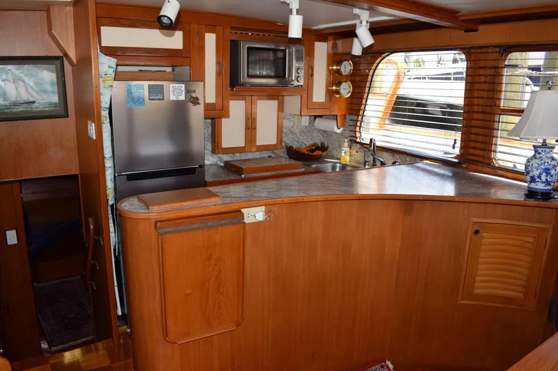 Slide: The Image of 1980 Cheoy Lee 52 Motorsailer interior kitchen with wood cabinetry and modern appliances. - 57