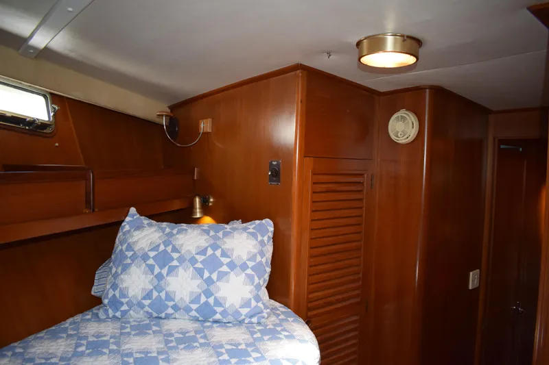 Slide: The Image of Cozy cabin interior of 1980 Cheoy Lee 52 Motorsailer with wooden paneling and blue quilted bedding. - 81