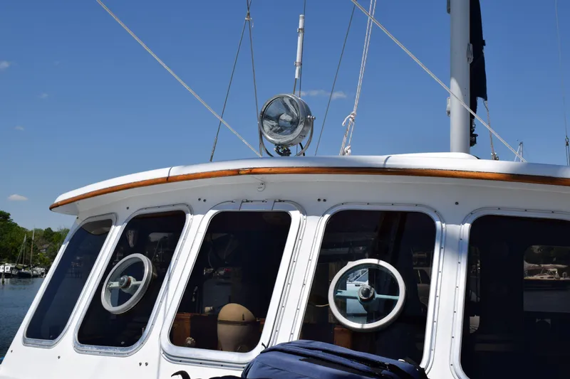 Slide: The Image of 1980 Cheoy Lee 52 Motorsailer with portholes and deck details under clear sky. - 25
