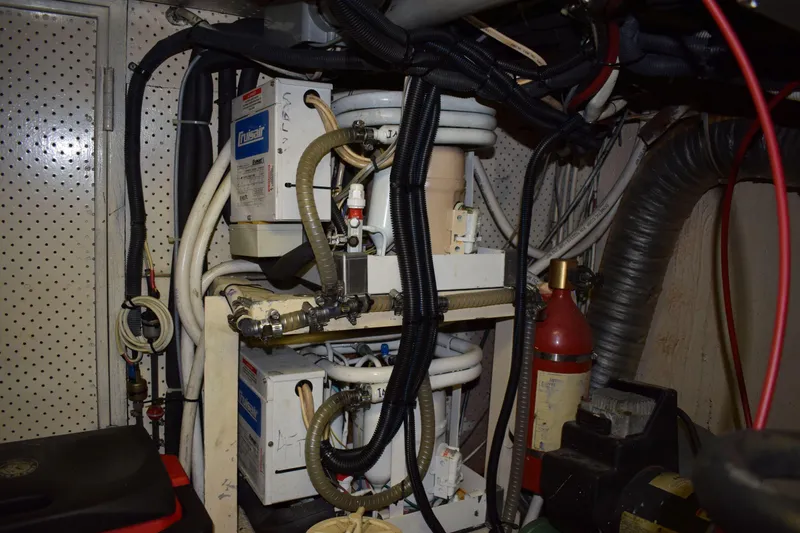 Slide: The Image of Engine room of a 1980 Cheoy Lee 52 Motorsailer with mechanical equipment and wiring. - 93