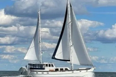 Slide: The Image of 1980 Cheoy Lee 52 Motorsailer sailing under blue skies with white clouds. - 100
