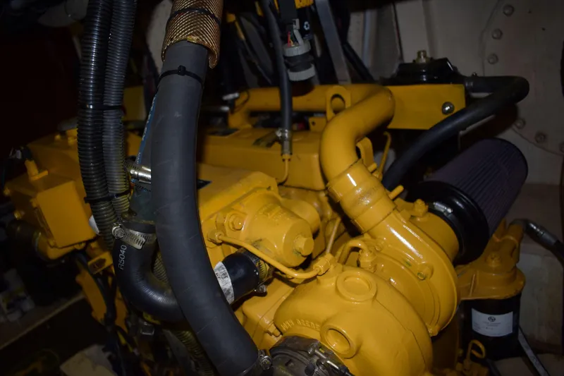 Slide: The Image of Engine of a 1980 Cheoy Lee 52 Motorsailer, showcasing yellow components and hoses. - 96