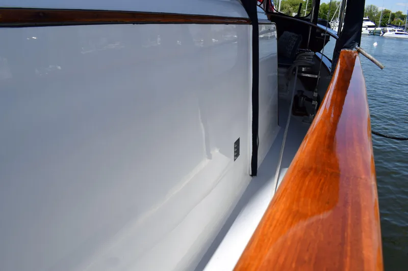 Slide: The Image of 1980 Cheoy Lee 52 Motorsailer with polished wood railing and sleek white hull. - 19