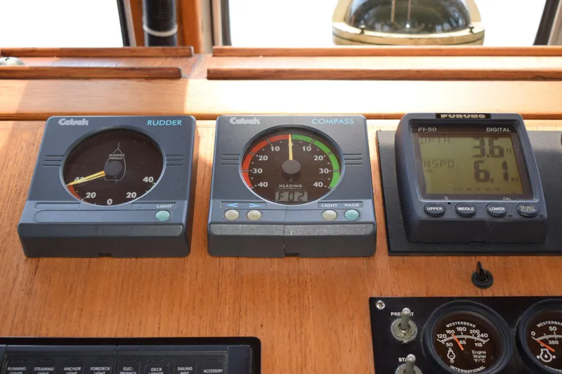 Slide: The Image of Instrumentation panel on a 1980 Cheoy Lee 52 Motorsailer, featuring rudder, compass, and digital displays. - 46