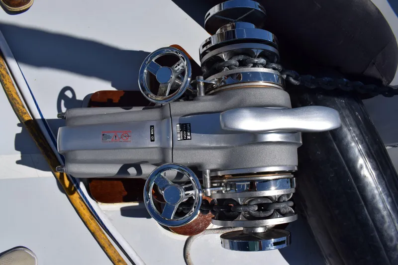 Slide: The Image of Anchor windlass on 1980 Cheoy Lee 52 Motorsailer deck, featuring chrome details and chain. - 20