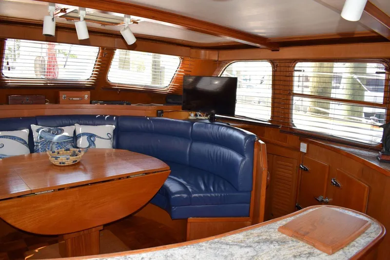 Slide: The Image of Interior of 1980 Cheoy Lee 52 Motorsailer with blue seating and wooden table. - 56