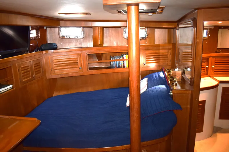 Slide: The Image of Cozy cabin interior of 1980 Cheoy Lee 52 Motorsailer with wooden furnishings and blue bedding. - 75
