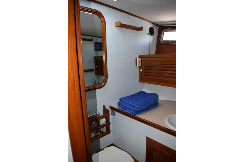 Slide: The Image of 1980 Cheoy Lee 52 Motorsailer bathroom with wooden accents and blue towels. - 90