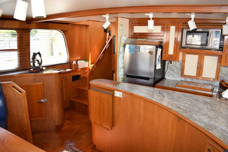 Slide: The Image of Interior of 1980 Cheoy Lee 52 Motorsailer with wooden cabinetry and modern kitchen appliances. - 58